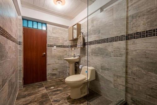 a bathroom with a toilet and a sink at ISA BELLA Hospedaje y Cabaña Entre Aves in Luna Park