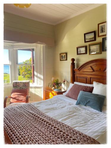 a bedroom with a large bed and a window at Waterfront Casilda Guesthouse in Dunalley