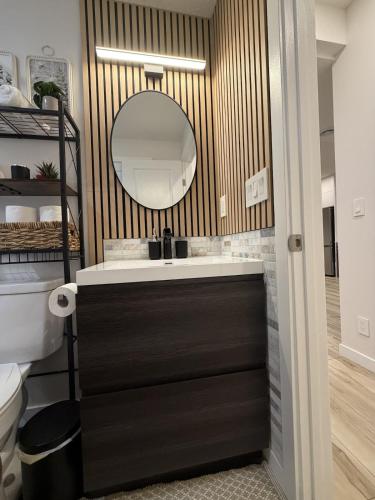 a bathroom with a sink and a mirror at The Ogieva Suites in Airdrie