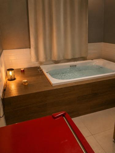 a bathroom with a tub with a candle and a candle at Flat com Jacuzzi em Capitólio - Cantinho do Lago 1 in Capitólio