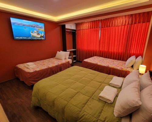 a hotel room with two beds and a tv on the wall at Andenes Perú in Puno