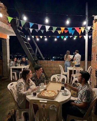 a group of people sitting at a table with a pizza at Andenes Perú in Puno