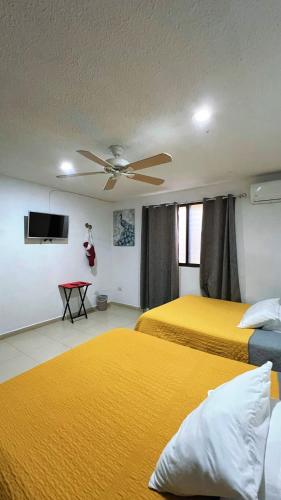 a bedroom with two beds and a ceiling fan at Home 365 Mérida Comodidad, amplitud total, 3 recamaras, 2 baños 5 camas ideal familias Consulado Americano in Mérida