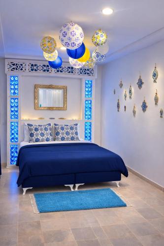 a bedroom with a blue bed with blue and white decorations at House Near the Sky in Dar Salah Bey