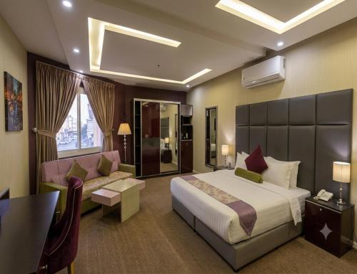 a hotel room with a bed and a couch at فندق نواة العزيزية in Medina