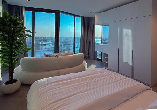 a bedroom with a bed and a couch and a window at Panoramic Nile View 3BR Apartment in Cairo
