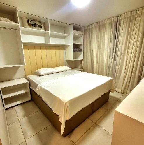 a small bedroom with a bed and open shelves at Salt Beach Atalaia Fort do Farol in Salinópolis