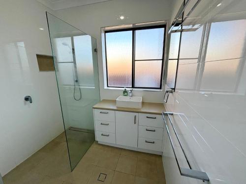 a bathroom with a sink and a glass shower at Seaview Townhouse 2 - Bring your own linen. in South West Rocks