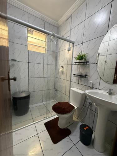 a bathroom with a toilet and a sink and a shower at Estadia rápida- Quarto 3 in Bayeux