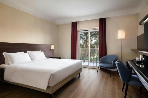 a hotel room with a bed and a window at Courtyard by Marriott Rome Central Park in Rome