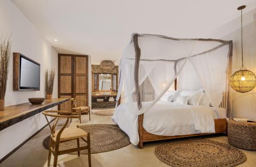a bedroom with a bed with a canopy at Villa Praia - La Villa Group in Jericoacoara