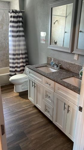 a bathroom with two sinks and a toilet and a shower at Journey House LA in Los Angeles