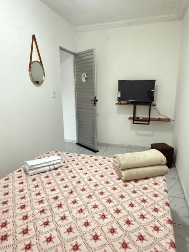 a bedroom with a bed and a television in it at Estadia rápida - Quarto 2 in Bayeux