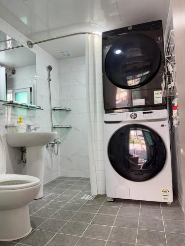 a washing machine in a bathroom with a toilet at 1&2 Stay in Daegu
