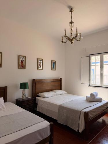 a bedroom with two beds and a chandelier at Herdade do Corval in Reguengos de Monsaraz