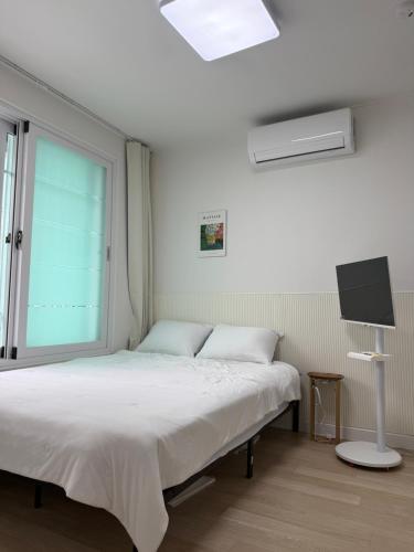 a bedroom with a bed with a window and a tv at 1&2 Stay in Daegu