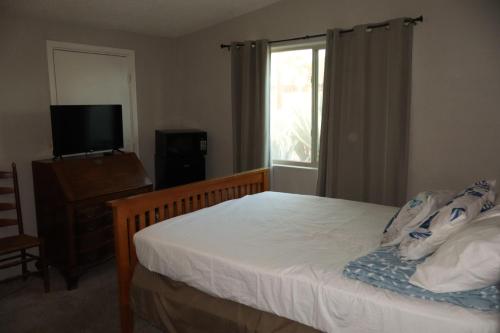 a bedroom with a bed and a television and a window at Dodge Residence in Tucson