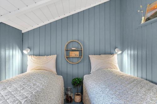 a bedroom with two beds and a mirror at 440-Hvide-Sande-Strandkrogvejen-60 in Hvide Sande