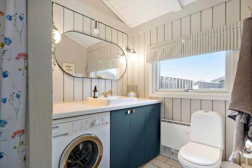 a bathroom with a washing machine and a sink at 440-Hvide-Sande-Strandkrogvejen-60 in Hvide Sande