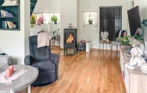 a living room with a chair and a fireplace at Nice Apartment In Rysstad With Wifi in Rysstad