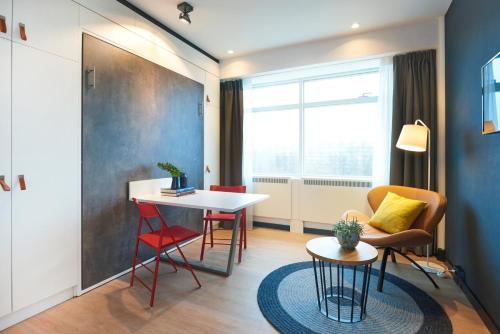 a small living room with a table and chairs at Cityden Zuidas in Amstelveen
