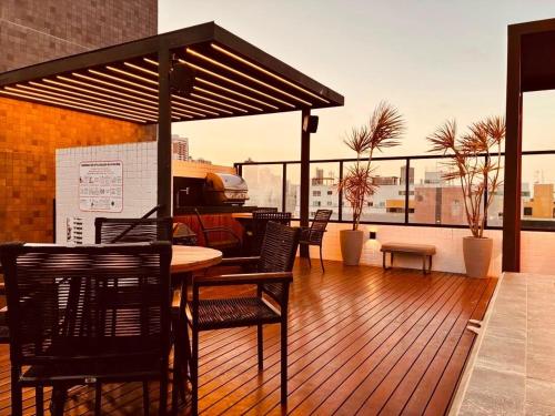 a deck with chairs and a table on a balcony at Get By Side na Beira mar do Caribessa Jardim Oceania in João Pessoa