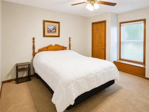 a bedroom with a large bed and a ceiling fan at Kaw Drive Guest House in Olathe