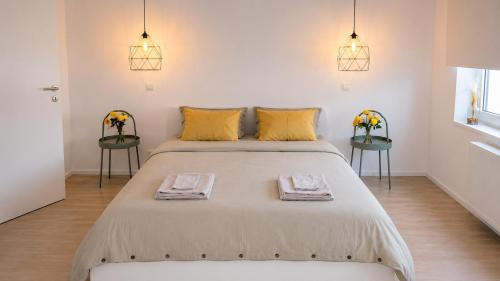 a bedroom with a large bed with two tables at Élégant stays in Vilvoorde