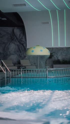 a large swimming pool with a large yellow umbrella at Motel Predejane in Predejane