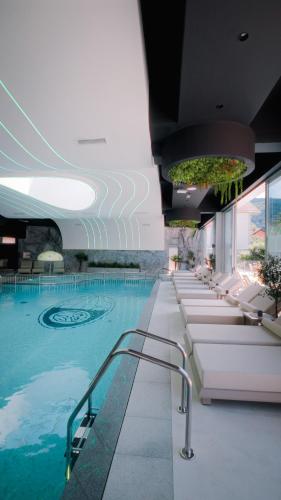 a swimming pool with lounge chairs in a building at Motel Predejane in Predejane