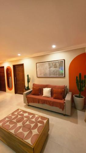 a living room with a bed and a couch at Brisas do Amor Apartamentos com jacuzzi privativa in Pipa