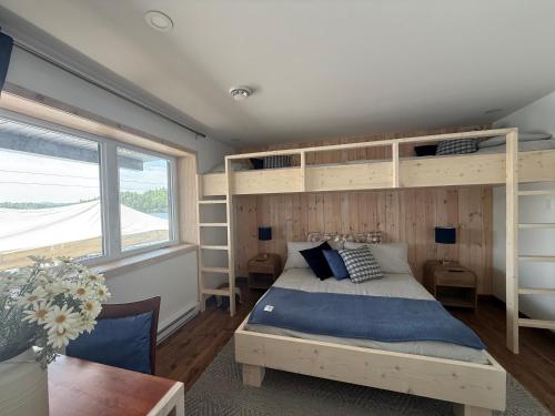 a bedroom with a bunk bed and a window at Le Quai 163 in La Macaza