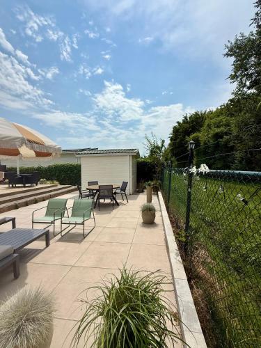 a patio with benches and tables and a fence at Vakantiewoning De Bosrand Aan Zee in Sint Annaland