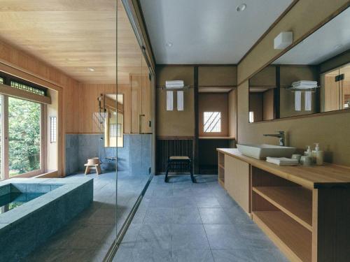 a bathroom with a tub and a sink at KAZENO Kurayoshi in Kurayoshi