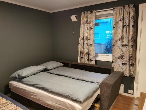 a bed sitting in a bedroom with a window at Siva's Apartment in Svolvær
