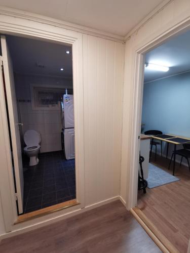 a bathroom with a toilet and a glass door at Siva's Apartment in Svolvær