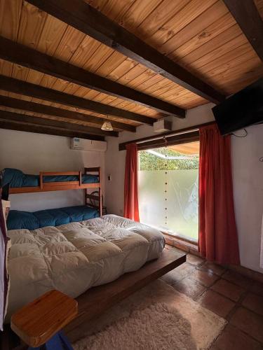 a bedroom with a bed and a large window at Ashpa apart in Cafayate