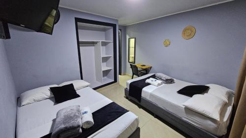 two beds in a hotel room with two beds sidx sidx sidx at aparta hotel continental estadio in Medellín