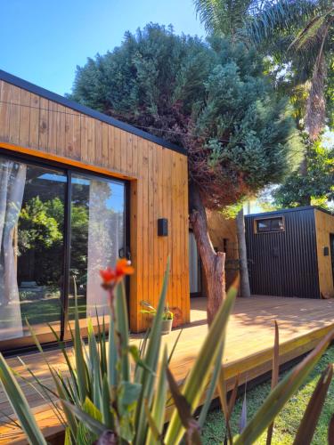 a house with a wooden deck with a tree at Bio Espacio in Belén de Escobar
