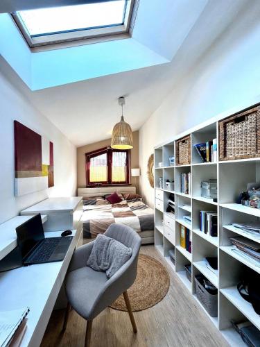 a room with a desk with a laptop and a bed at InOut Dom Olsztyn in Olsztyn