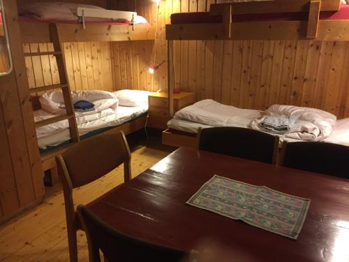 a room with a table and two bunk beds at Putten Seter in Høvringen
