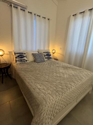 a bedroom with a large bed with white curtains at Serene Shores, Punta Azul, Westpunt in Westpunt