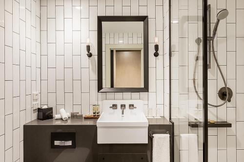 a white bathroom with a sink and a mirror at DoubleTree by Hilton Melbourne in Melbourne