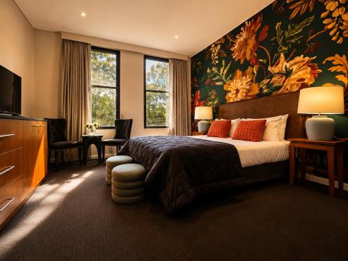 a bedroom with a large bed with a floral wallpaper at The Grand Oaks in Beechworth