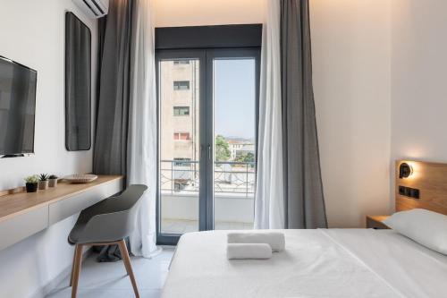 a bedroom with a bed and a desk and a window at White Tower Elegance in Thessaloniki