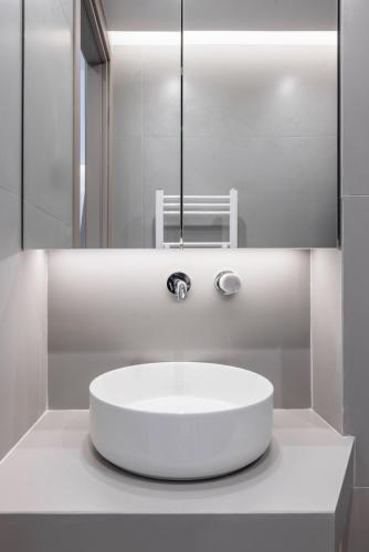 a white bathroom with a sink and a mirror at White Tower Elegance in Thessaloniki
