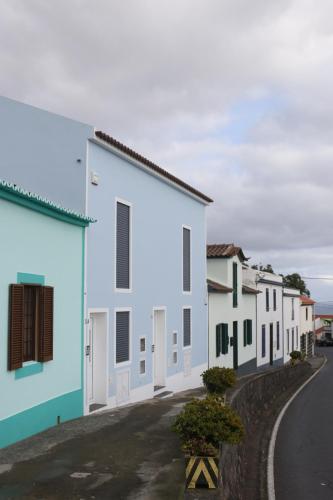 a row of white and blue buildings on a street at Cantinho Das Praias in Vila Franca do Campo