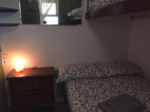 ein Schlafzimmer mit einem Bett und einem Nachttisch mit einer Lampe in der Unterkunft meschihouse - Chesa Engadina in Samedan