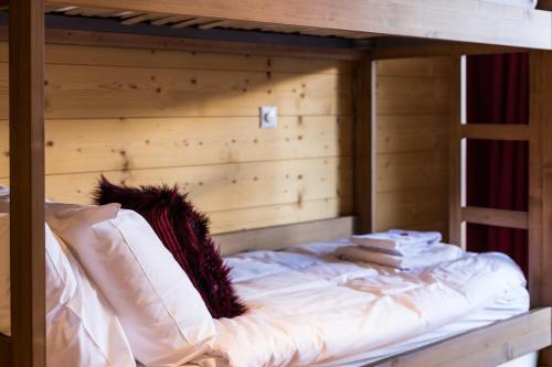 a wooden bunk bed with white sheets and pillows at Chalet Les Rahâs by Mrs Miggins in Grimentz