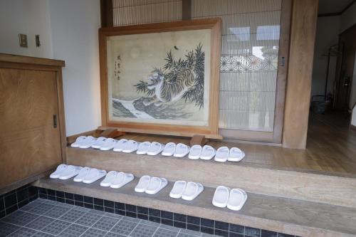 a row of white shoes on a shelf in a room at Samurai Hotel - Vacation STAY 22111v in Fujiyoshida